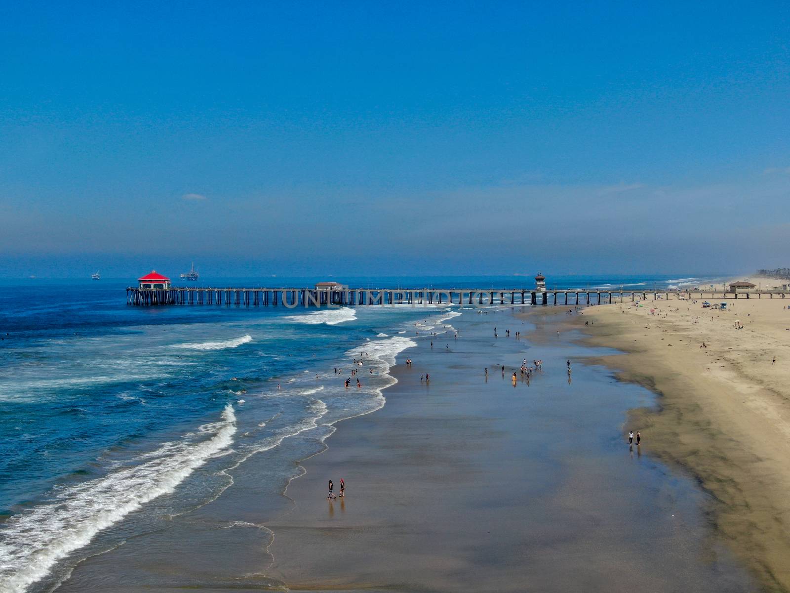 Aerial view of Huntington Pier, beach and coastline during sunny summer day by Bonandbon