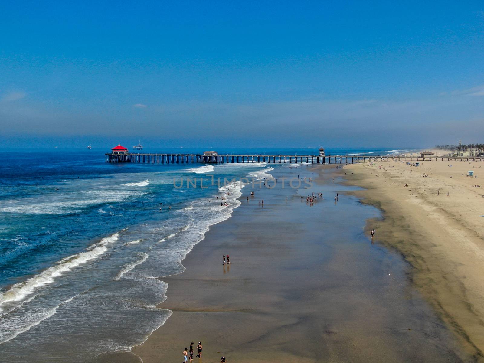 Aerial view of Huntington Pier, beach and coastline during sunny summer day by Bonandbon