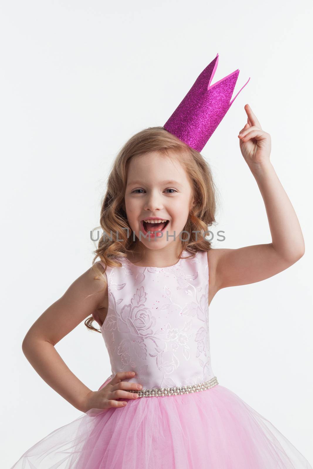 Funny princess girl in pink dress and crown with finger up isolated on white background