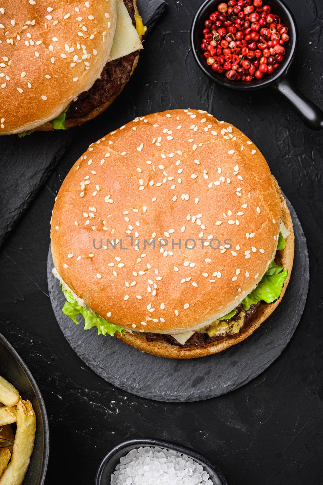 Tasty grilled home made burger on black textured background.