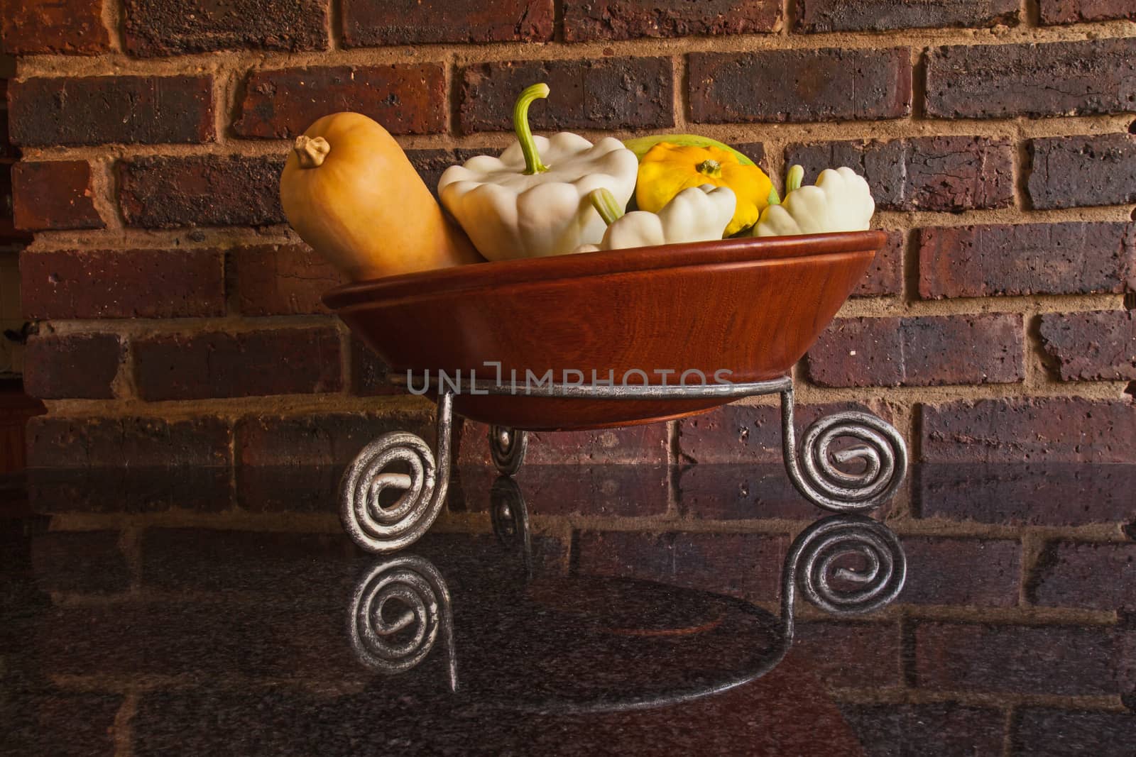 An arrangement of different pumpkins in a wooden bowl showing the gardener's successful crop.