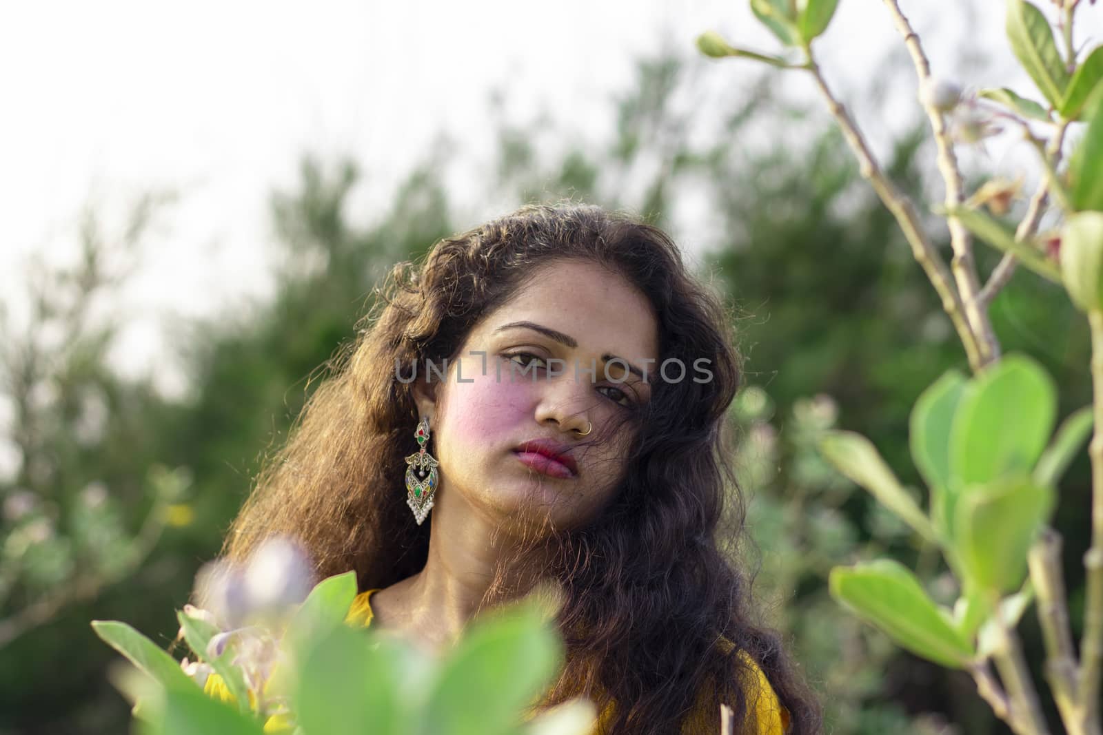 A beautiful Asian woman faces open hair with selective focus points background, outdoors closeup portrait