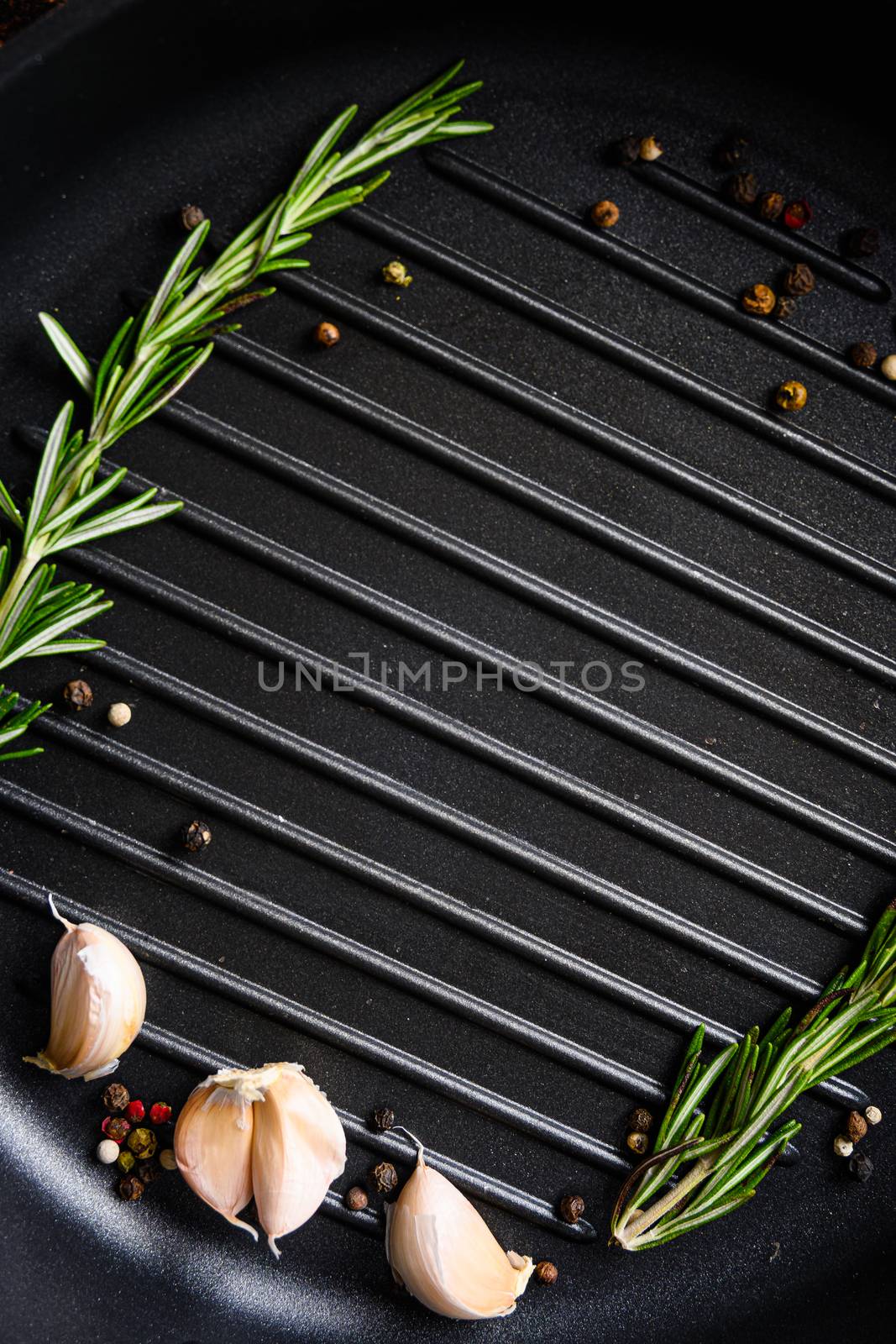 barbecue grill frying pan or skillet close up black with herbs for cooking top view concept for text or objects vertical by Ilianesolenyi