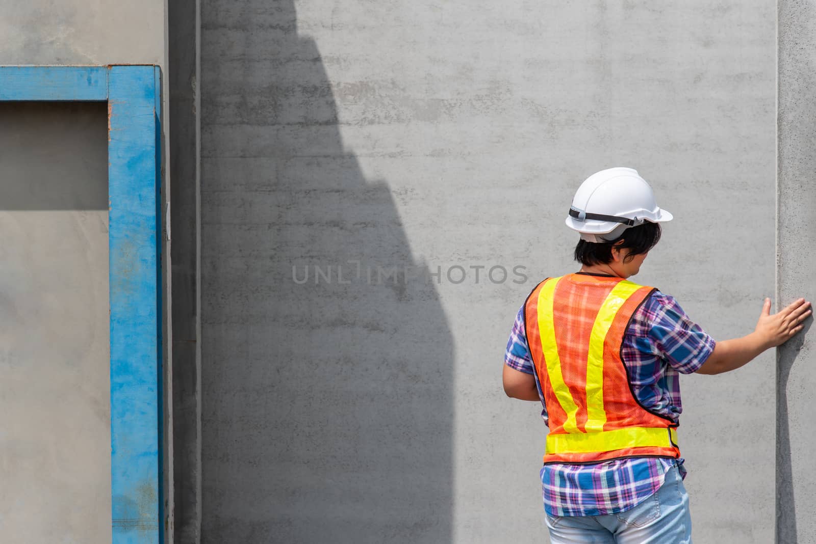 Asian woman civil construction engineer worker or architect with helmet and safety vest happy working at a building or construction site