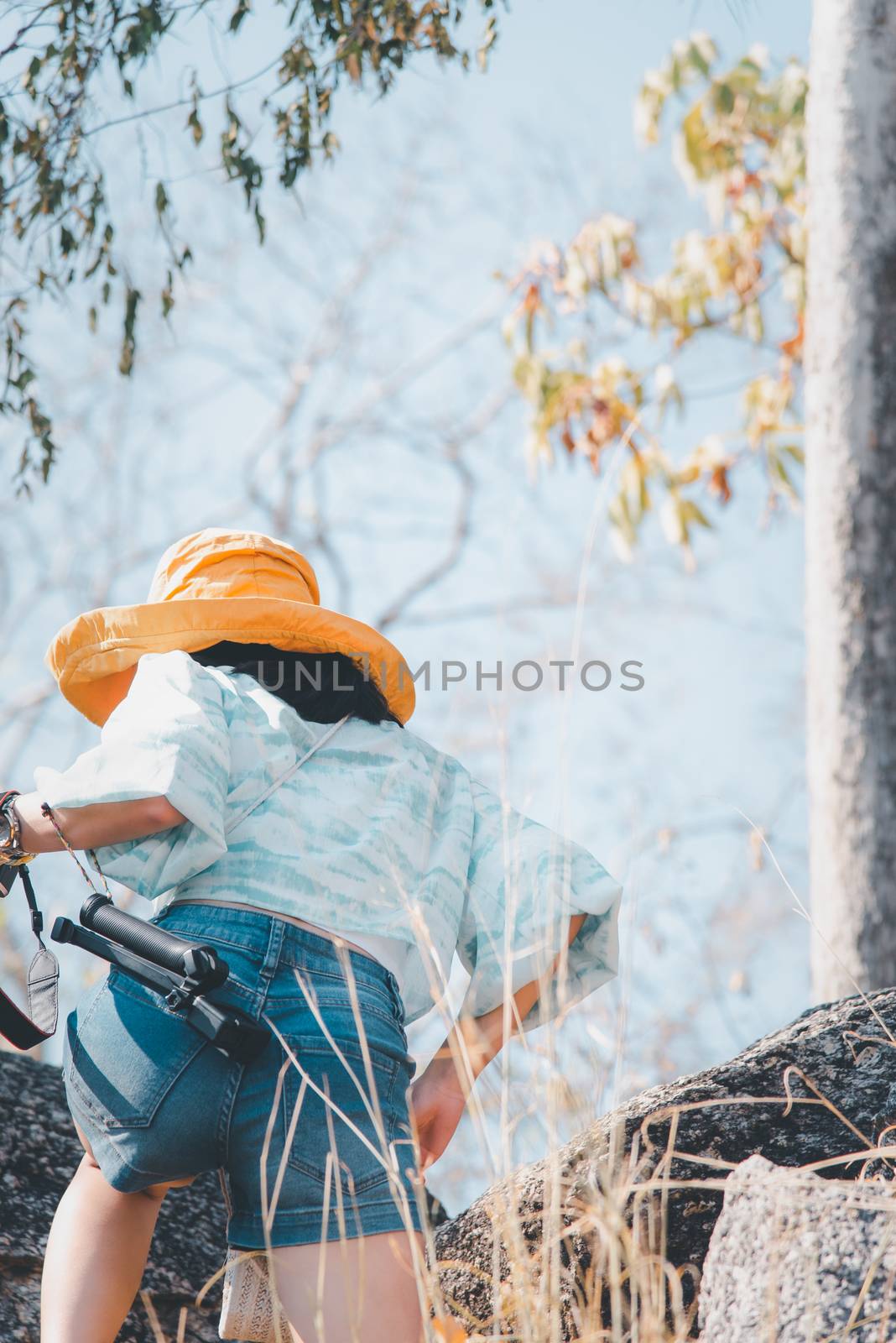 Woman hiking in forest on mountain with cliff by PongMoji
