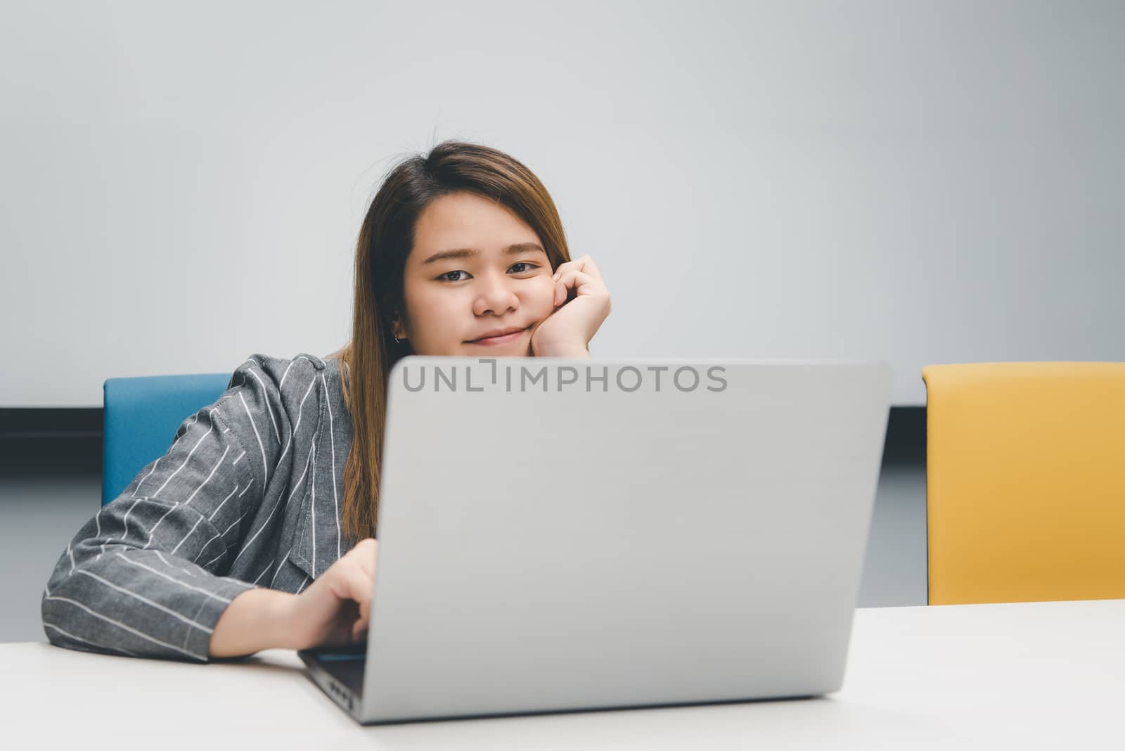 Woman working by laptop in office with happy by PongMoji