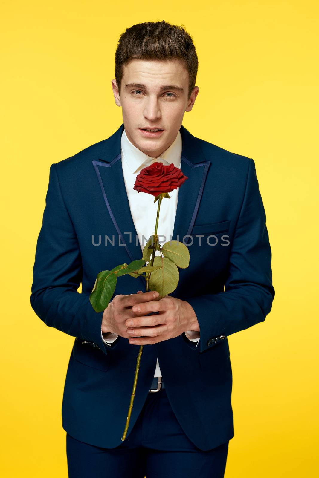 Gentlemen in classic suit on yellow background and red rose romance cropped view model portrait. High quality photo