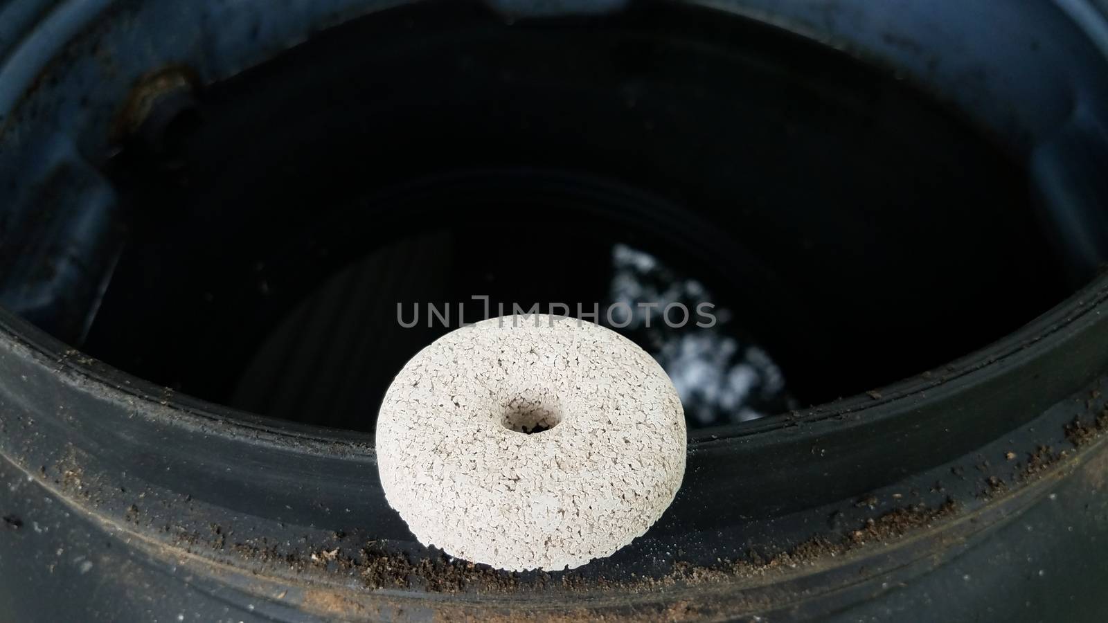 circular white mosquito tablet insecticide on edge of rain barrel by stockphotofan1