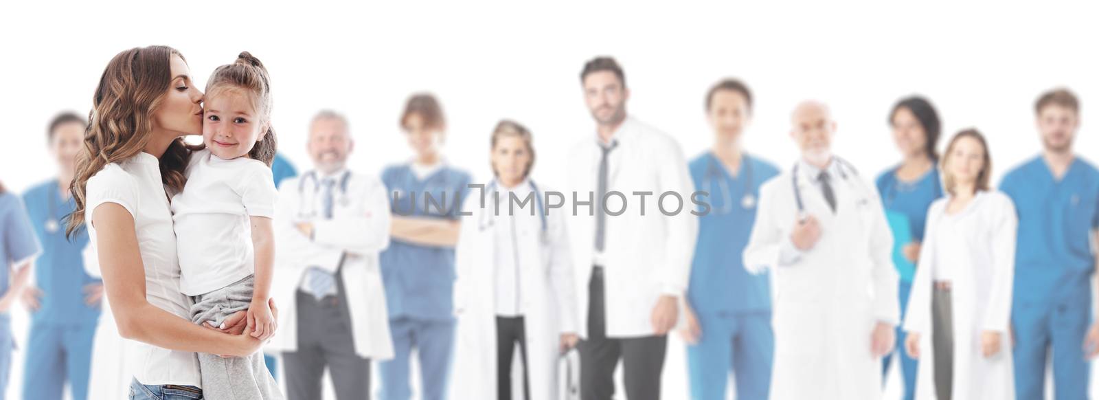 Mother kisses her daughter, team of doctors in medical clinic on background isolated on white