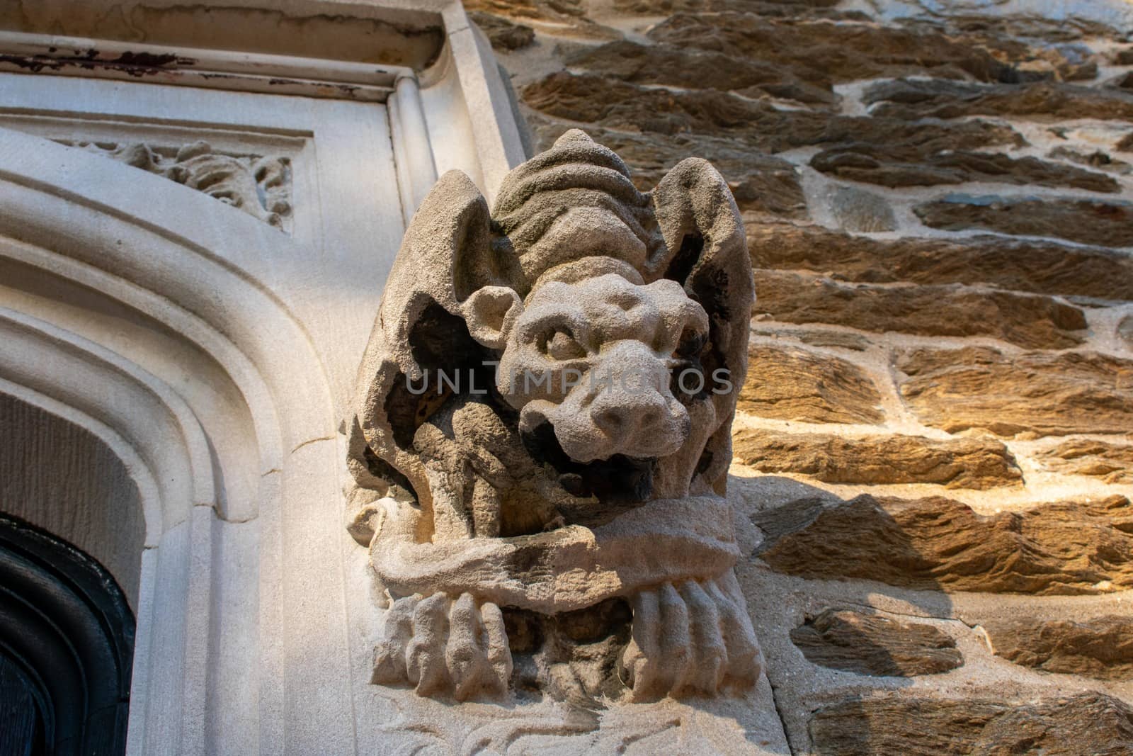 A Gargoyle Statue Sticking Out of the Wall Next to a Doorway at  by bju12290