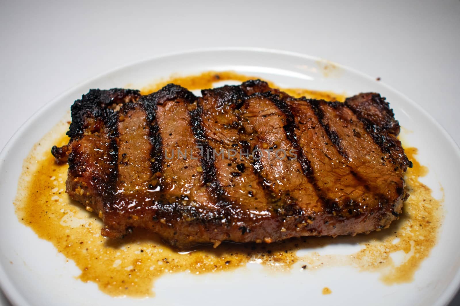 A Perfectly Grilled Steak Plated on a Pure White Background by bju12290