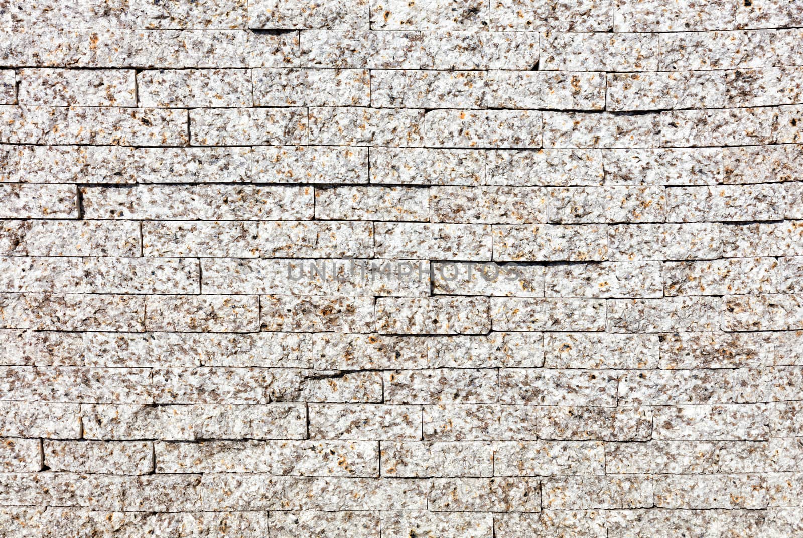 The wall is faced with gray granite stripes, close-up. by Sergii