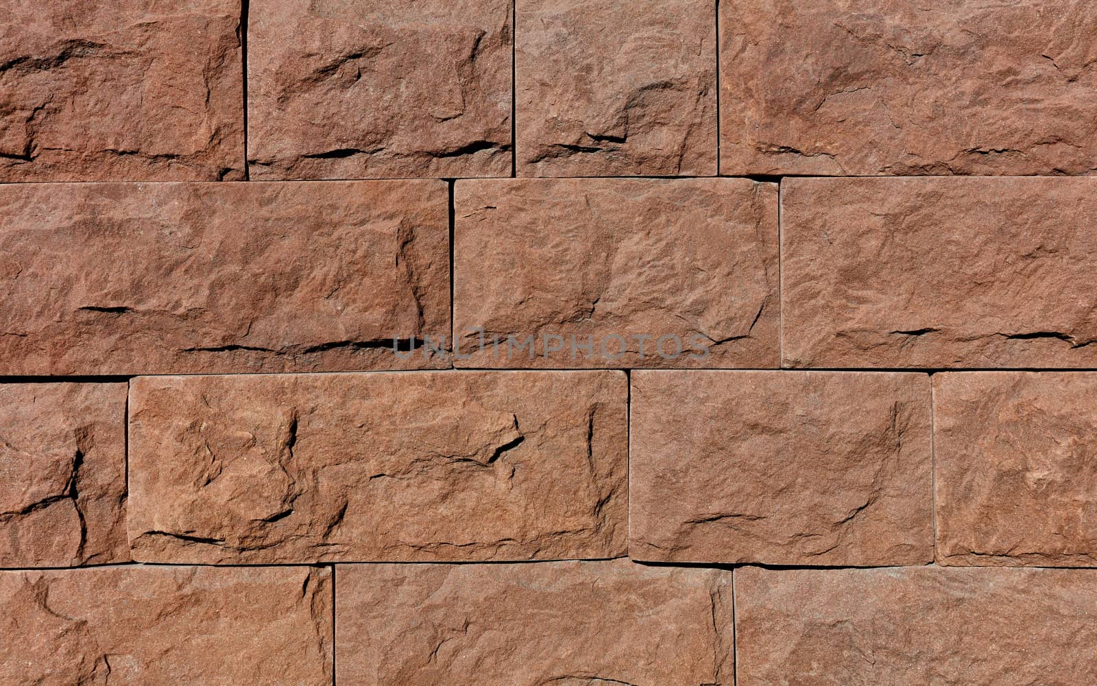 The wall is tiled with brown granite tiles, each chipped around the perimeter. by Sergii