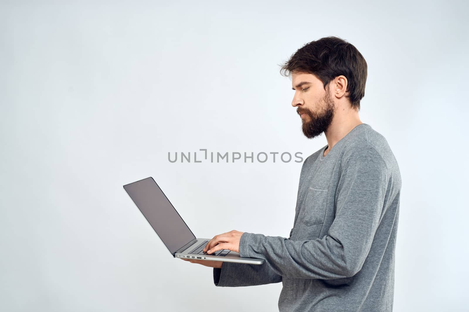 A man in a gray sweater with a laptop hands lifestyle technology communication internet work. High quality photo