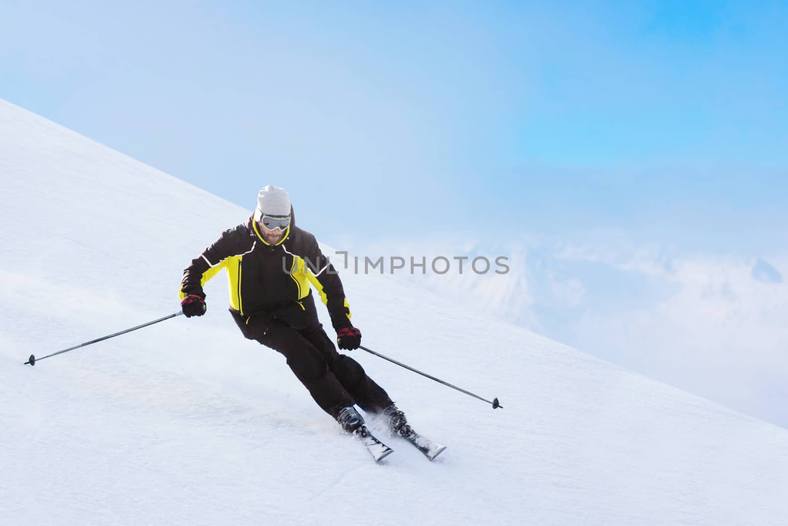 Alpine skier on piste running downhill by destillat