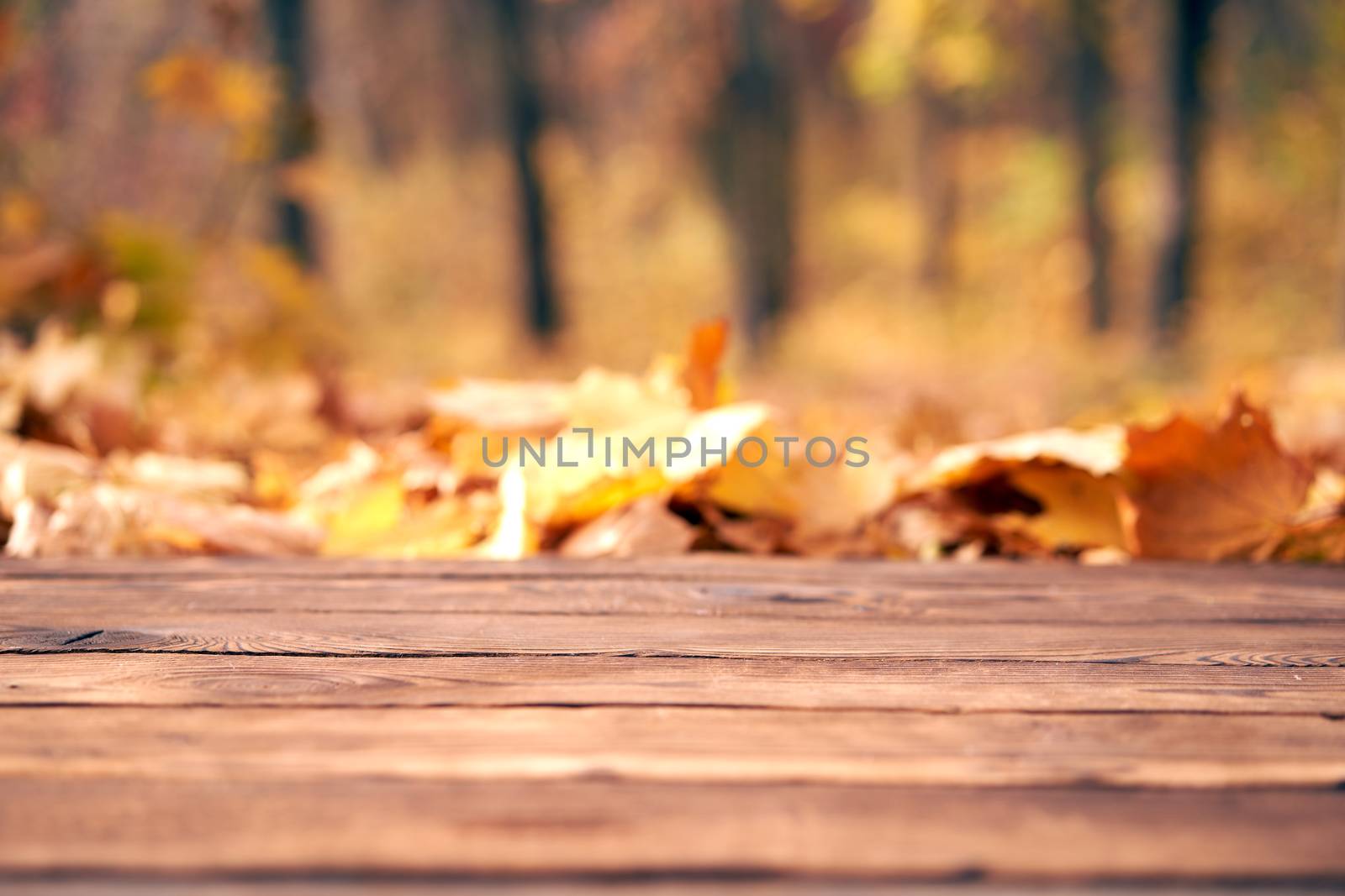 Empty wooden table autumn maple leaves nature bokeh background with a country outdoor theme,Template mock up for display of product Copy space