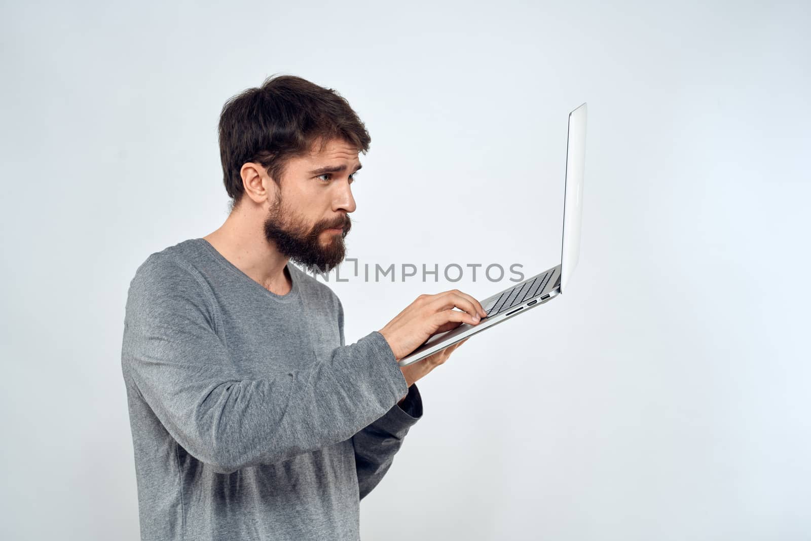 Bearded man with laptop in hands internet communication technology light background by SHOTPRIME