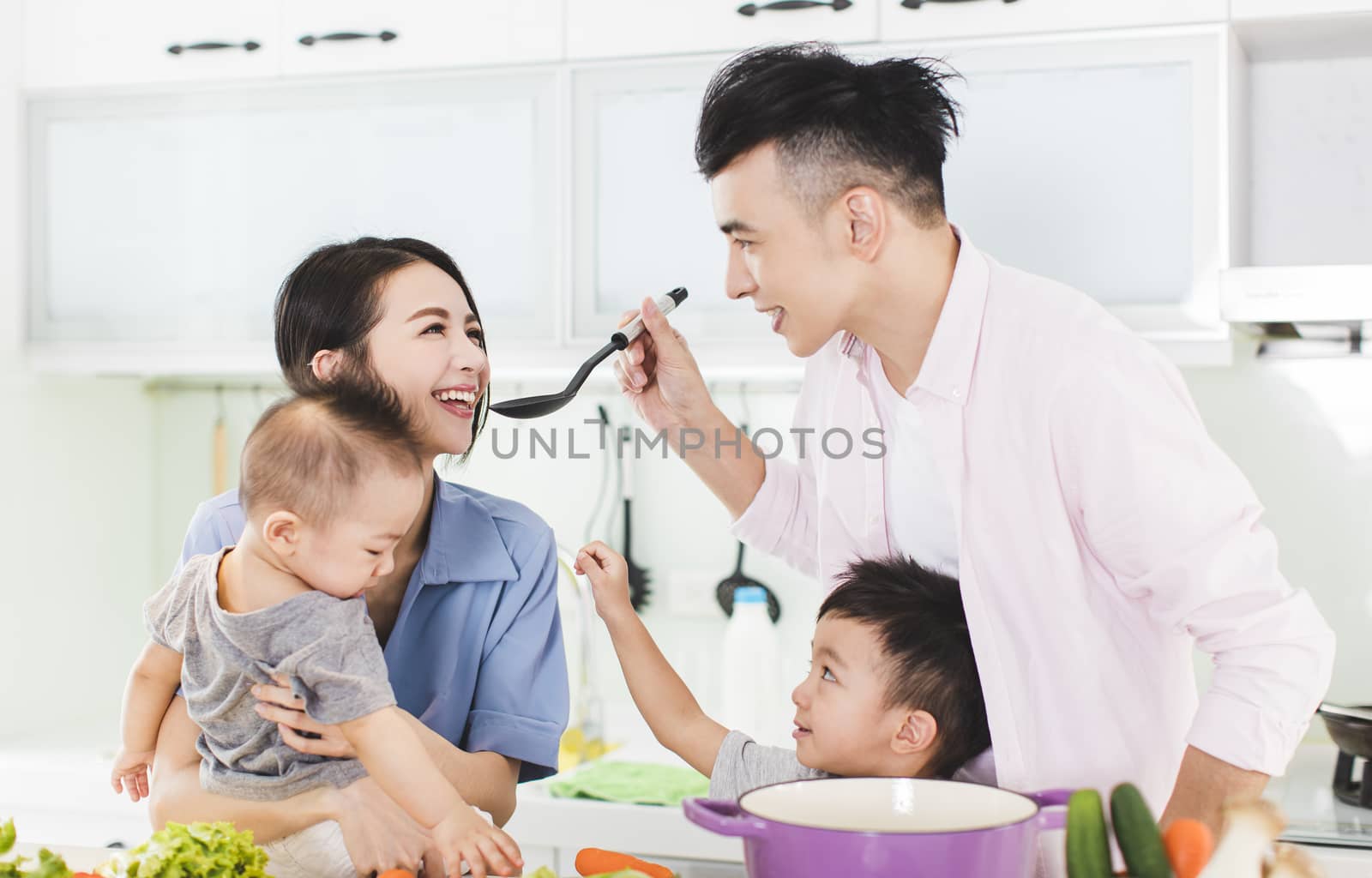 happy family tasting the soup in kitchen by tomwang