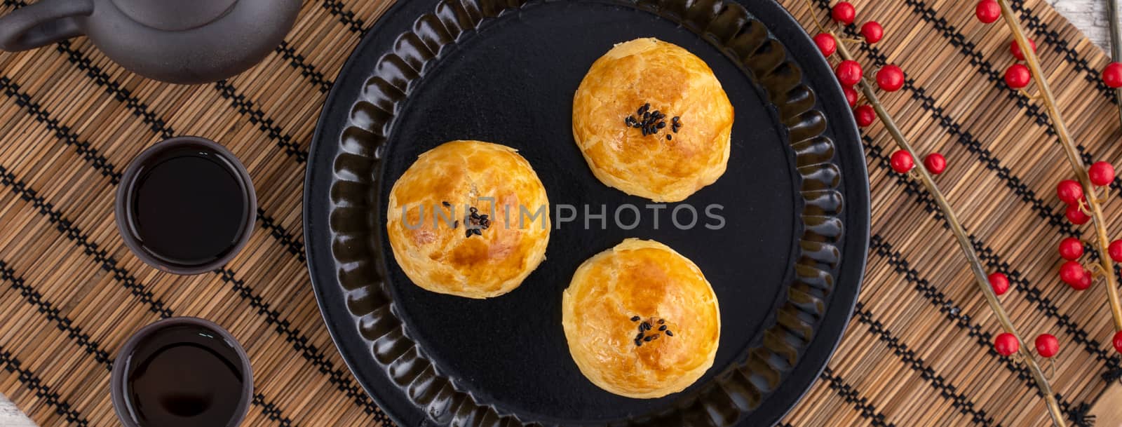 Moon cake yolk pastry, mooncake for Mid-Autumn Festival holiday, top view design concept on bright wooden table with copy space, flat lay, overhead shot