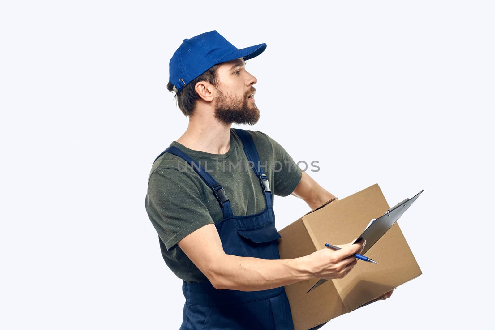 Man in working uniform box delivery loader courier light background. High quality photo