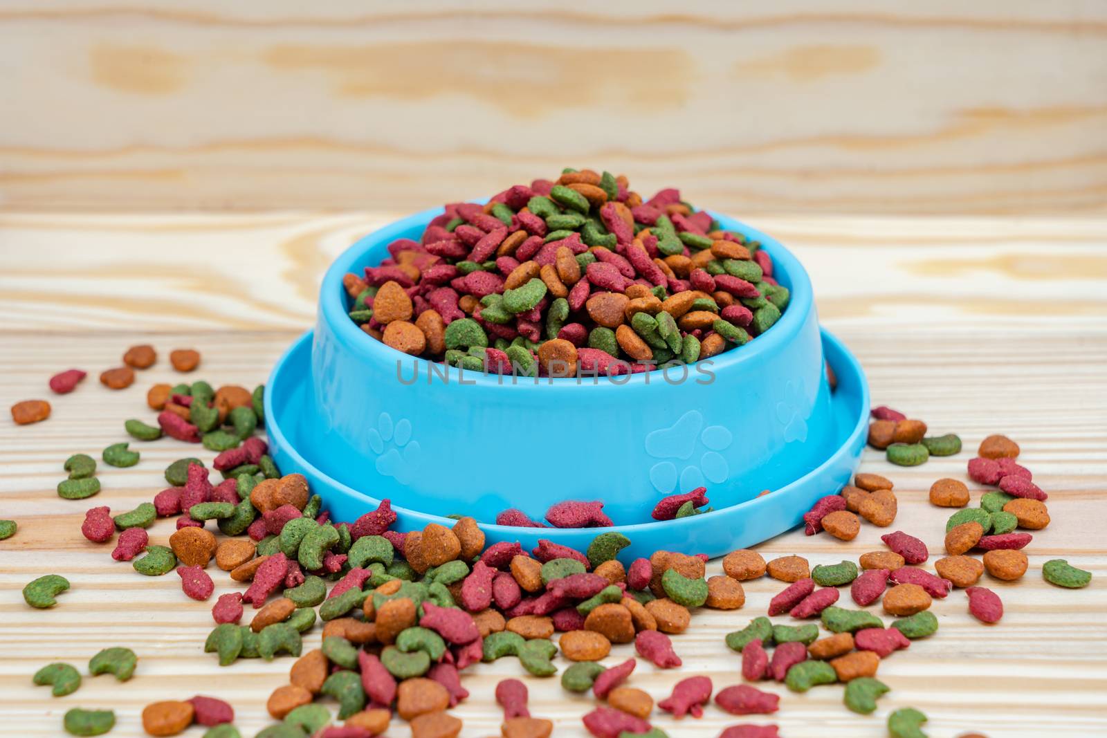 Pet food in bowl on wooden background by Buttus_casso