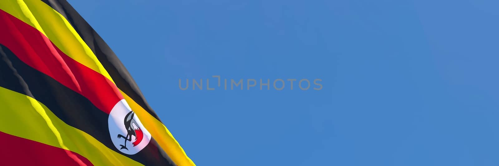 3D rendering of the national flag of Uganda waving in the wind against a blue sky