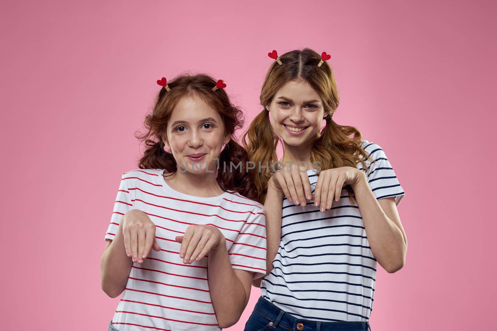 Cheerful mom and daughter lifestyle joy striped shirts family pink background by SHOTPRIME