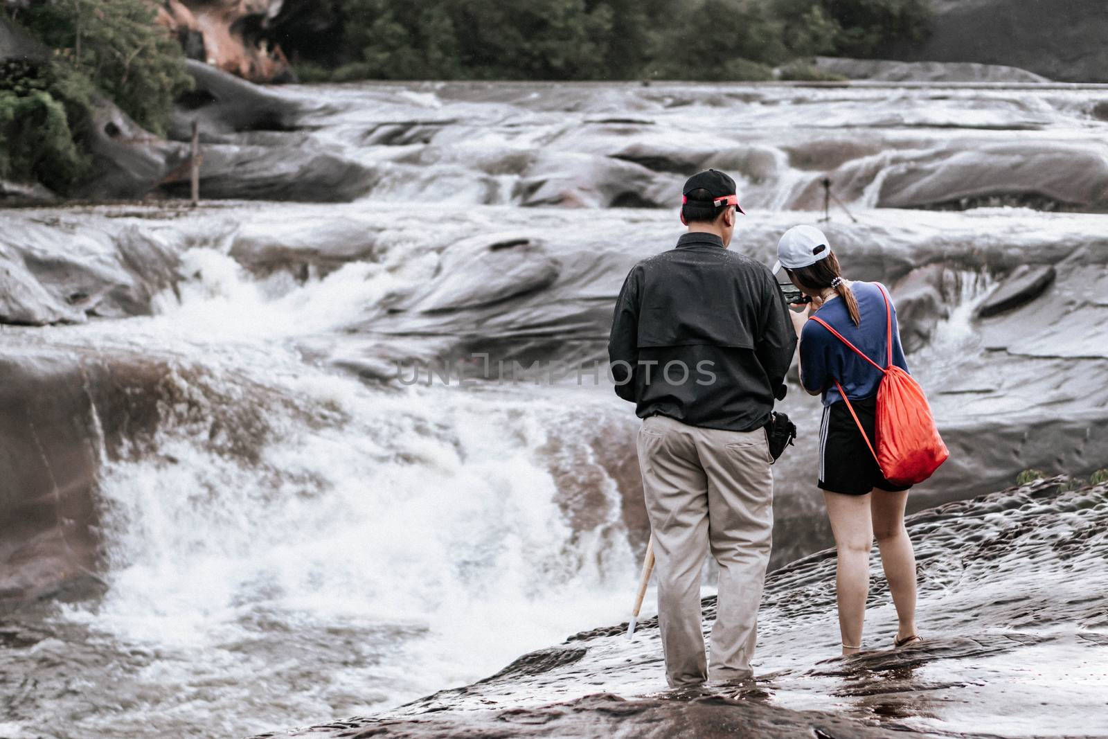 tourist take a photo with waterfall