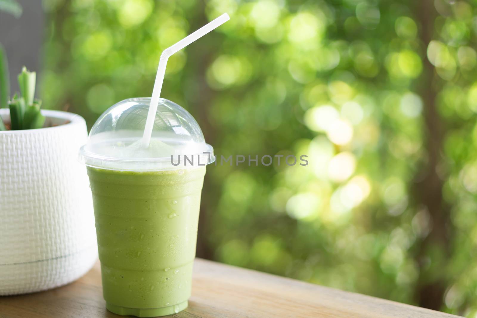 Close up glass of ice matcha green tea on wood table, selective  by pt.pongsak@gmail.com