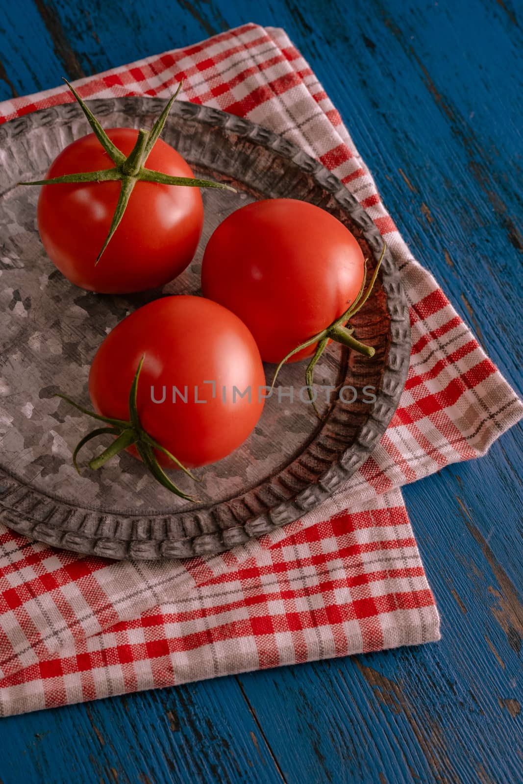 Fresh tomatoes in rustic style on a blue wooden background.