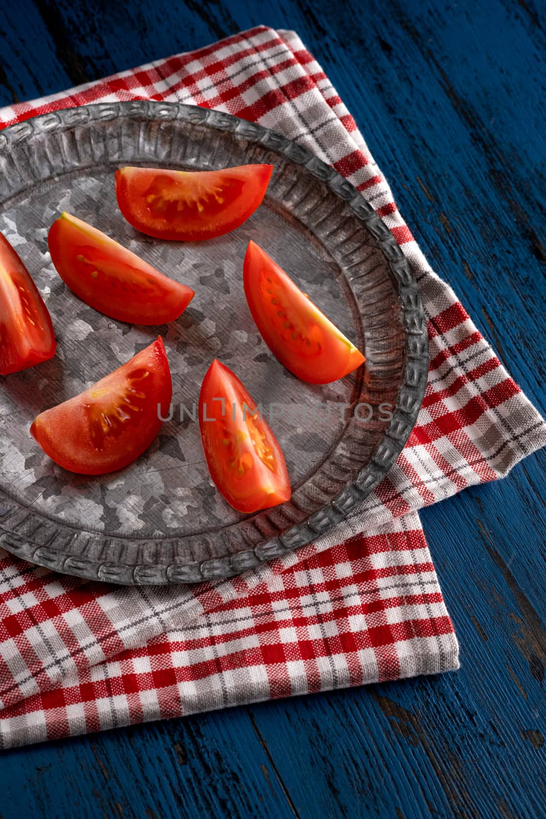 Fresh tomatoes in rustic style on a blue wooden background by Fischeron