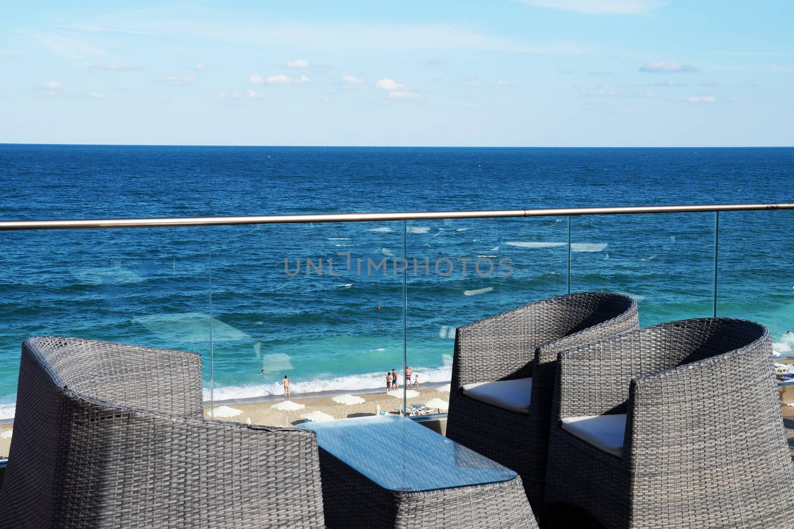 armchairs and a table for relaxing on the patio overlooking the sea.