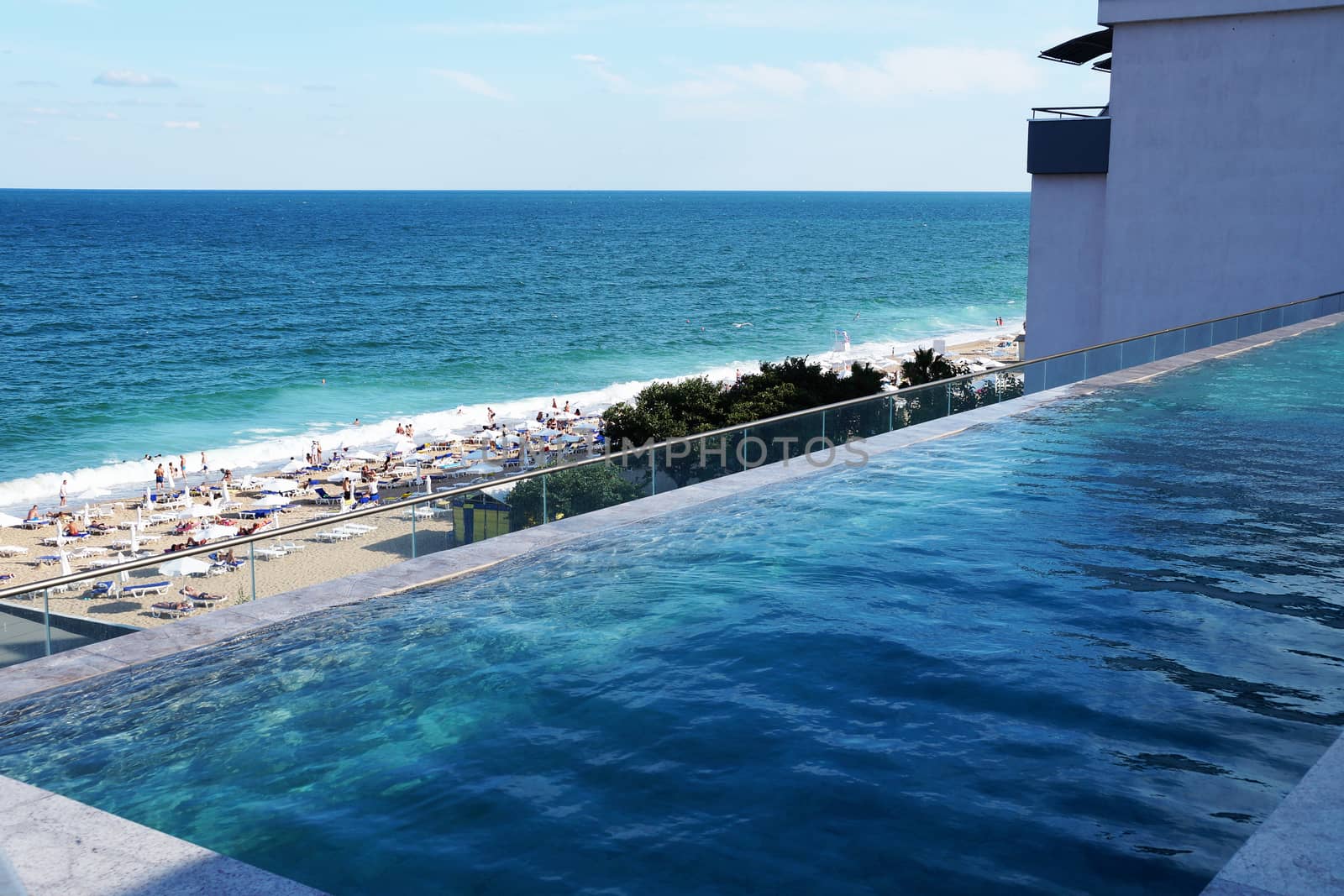 outdoor rooftop pool with sea view on sunny day by Annado