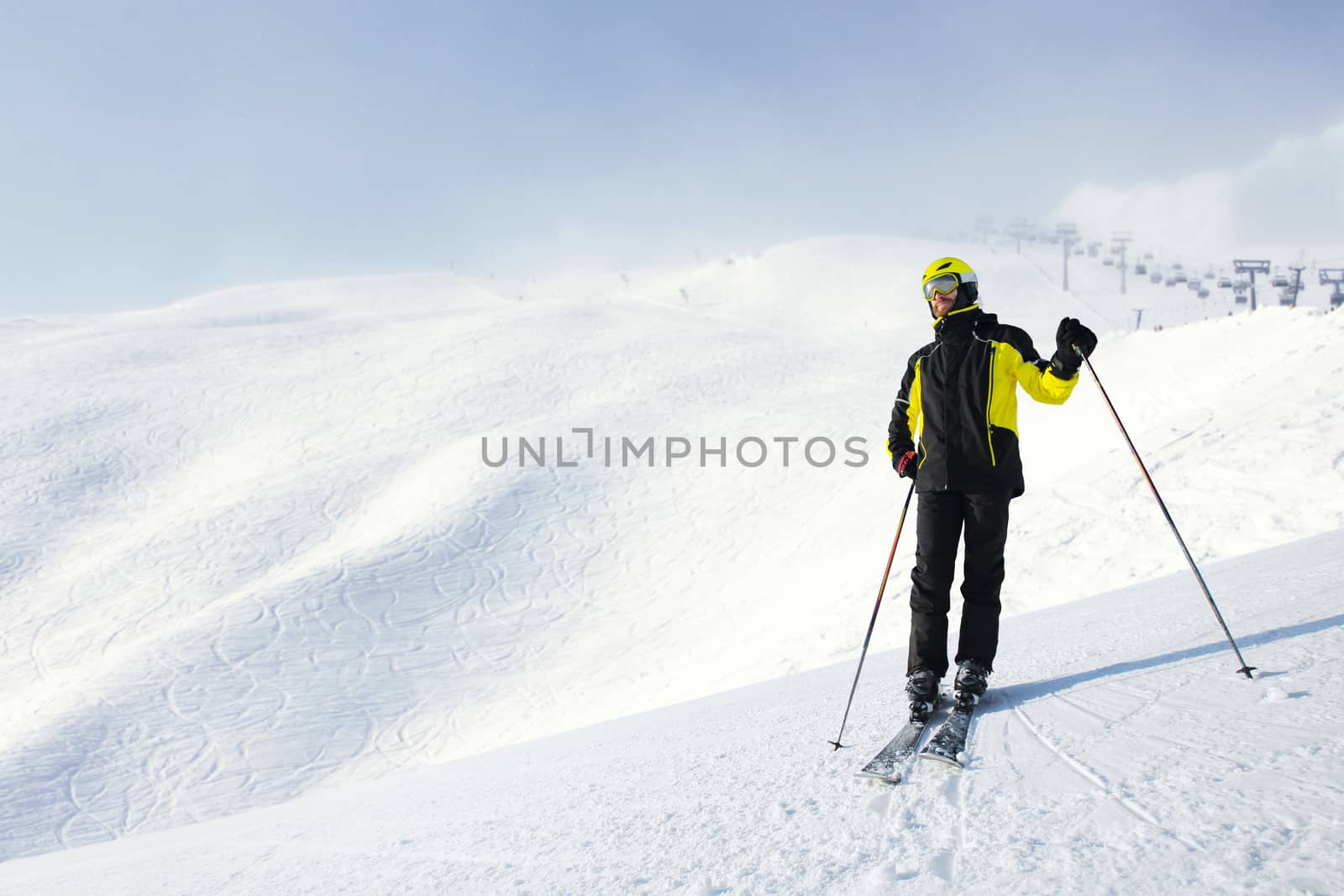 Skier standing alone and looking at panoramic view at Alps mountains ski resort copy space for text