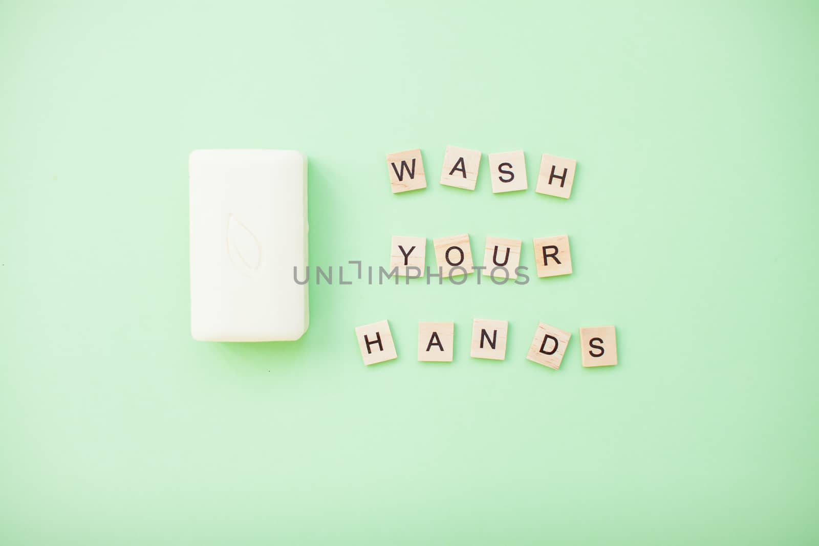 inscription from wooden blocks wash your hands and soap on a light green background