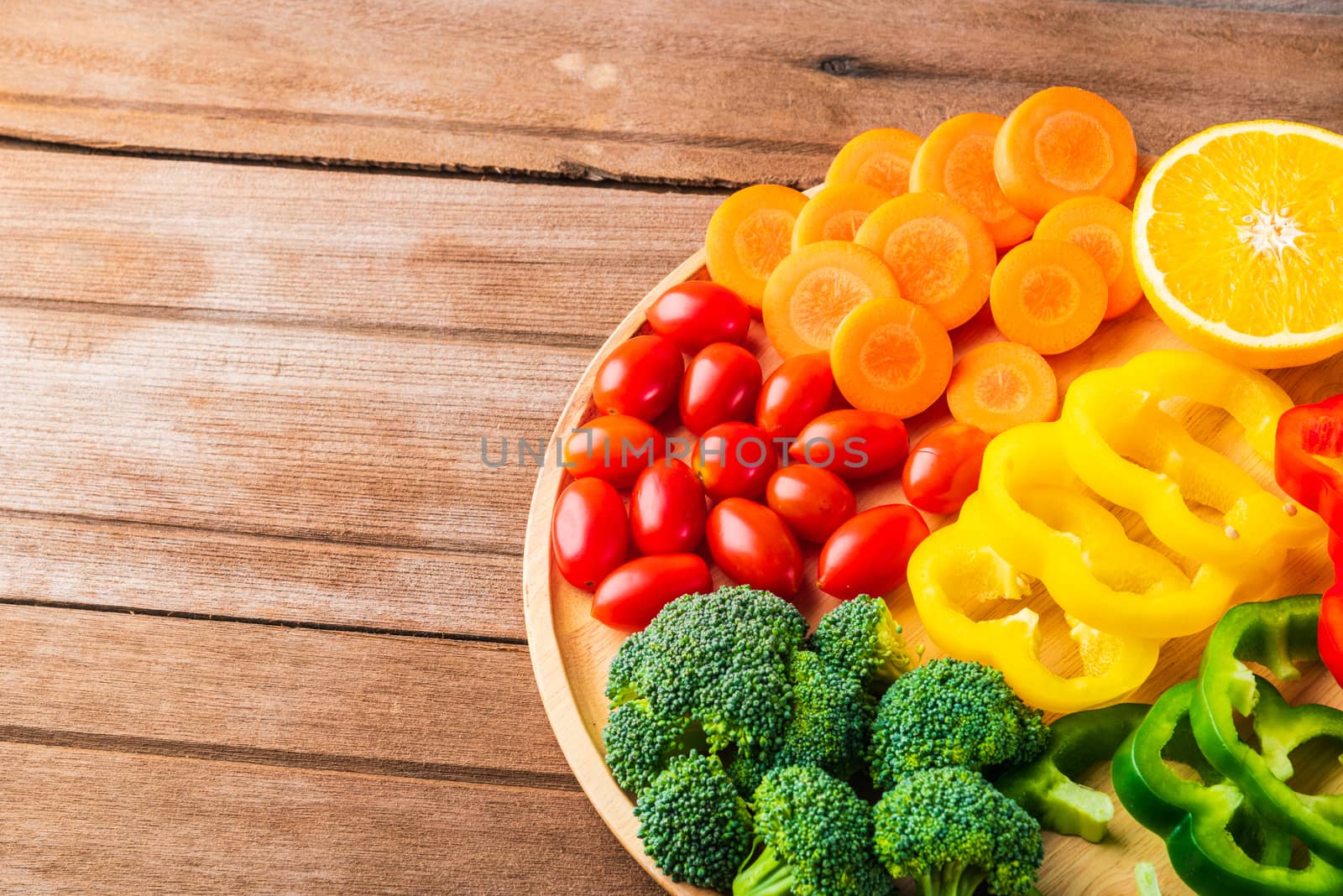 Top view of fresh organic fruits and vegetables in plate wood (carrot, Broccoli, tomato, orange, Bell pepper) on wooden table, Healthy lifestyle diet food concept