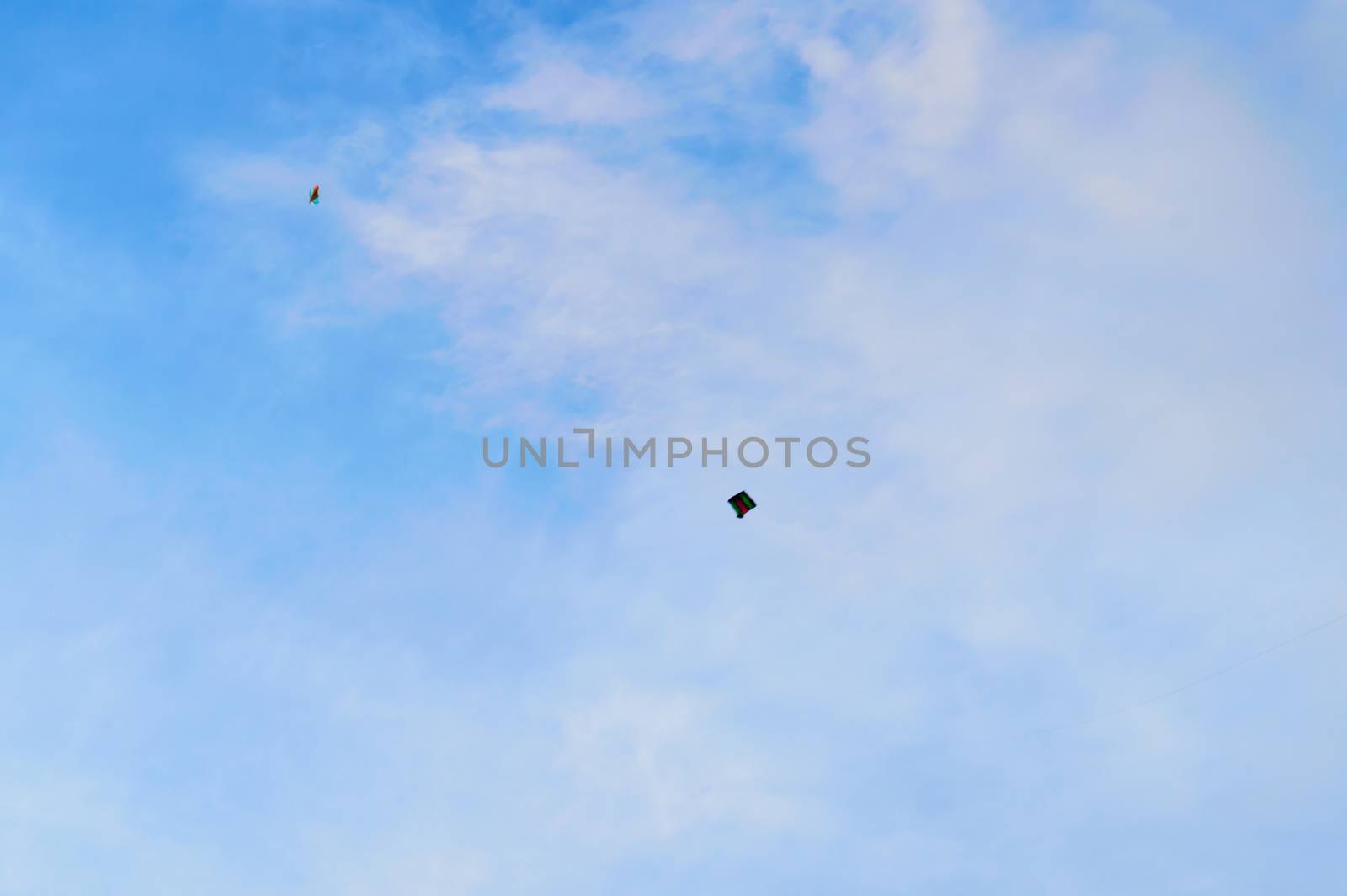 Kite flying in the sky. Kites flying picture with blue sky and white clouds. Photography in the eve of Vishwakarma Puja in Kolkata. Low angel View. Motion Blur. by sudiptabhowmick