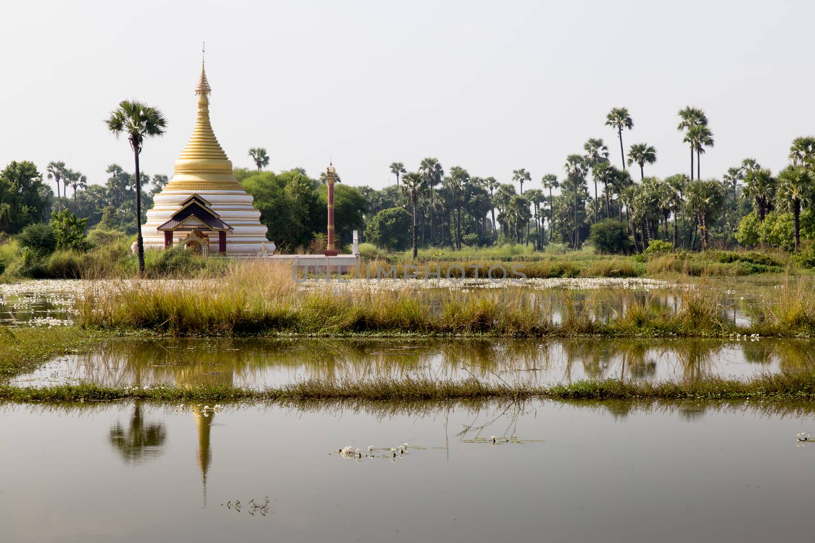 Inwa Island, Mandalay, Myanmar, stupa and temple in landscape reflected in water by kgboxford