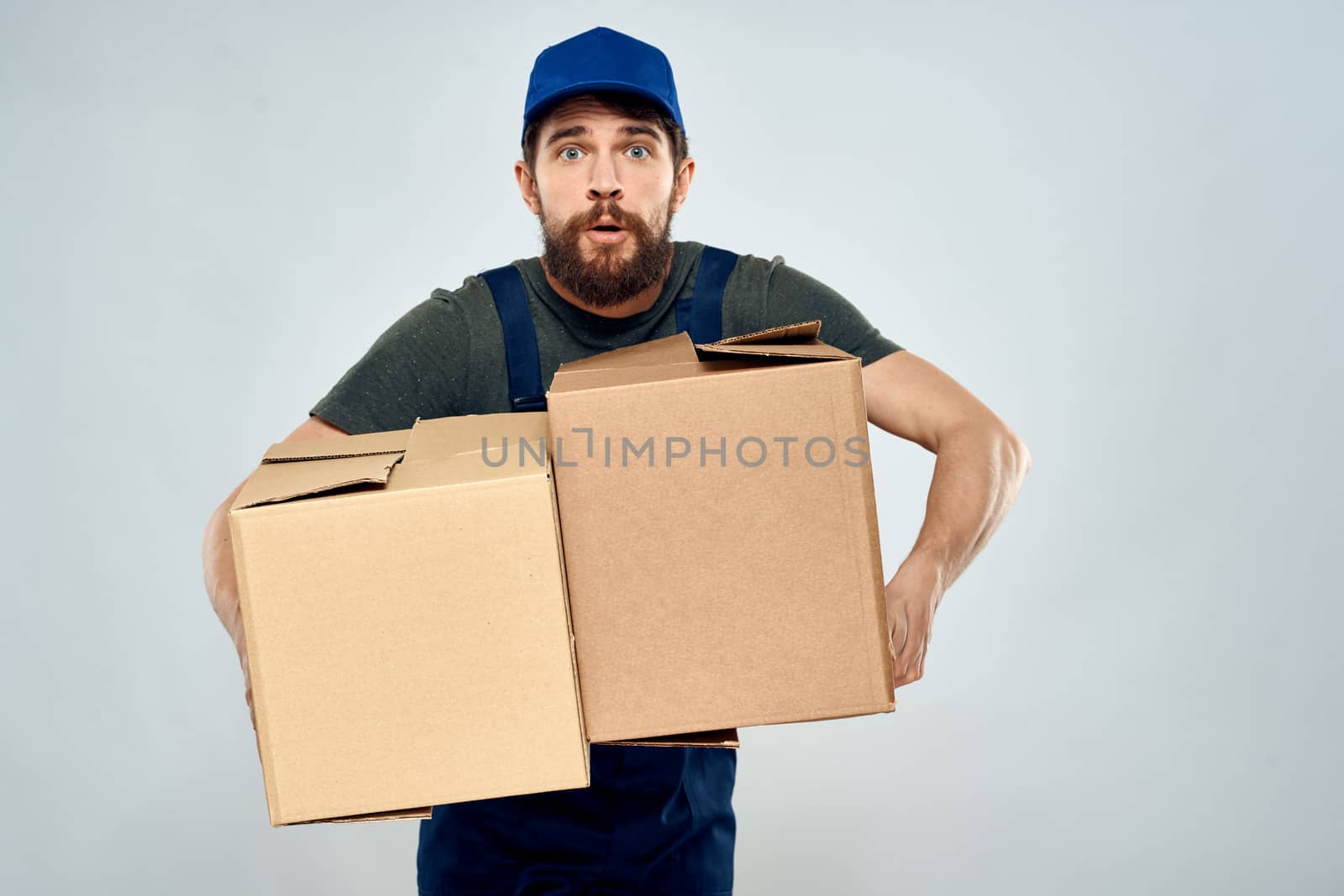 Man in working uniform with boxes in hands delivery loading lifestyle. High quality photo