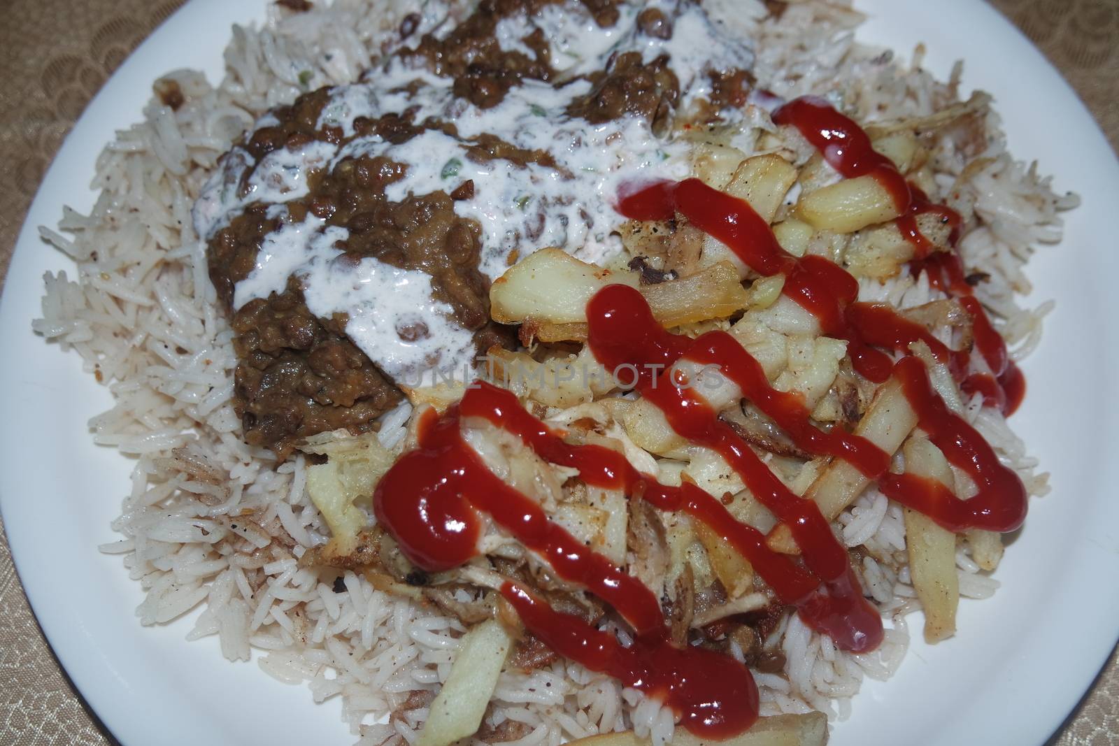 Delicious traditional dish of rice with potato fries and cereals with red ketchup. Food background with copy space for text and advertisements.