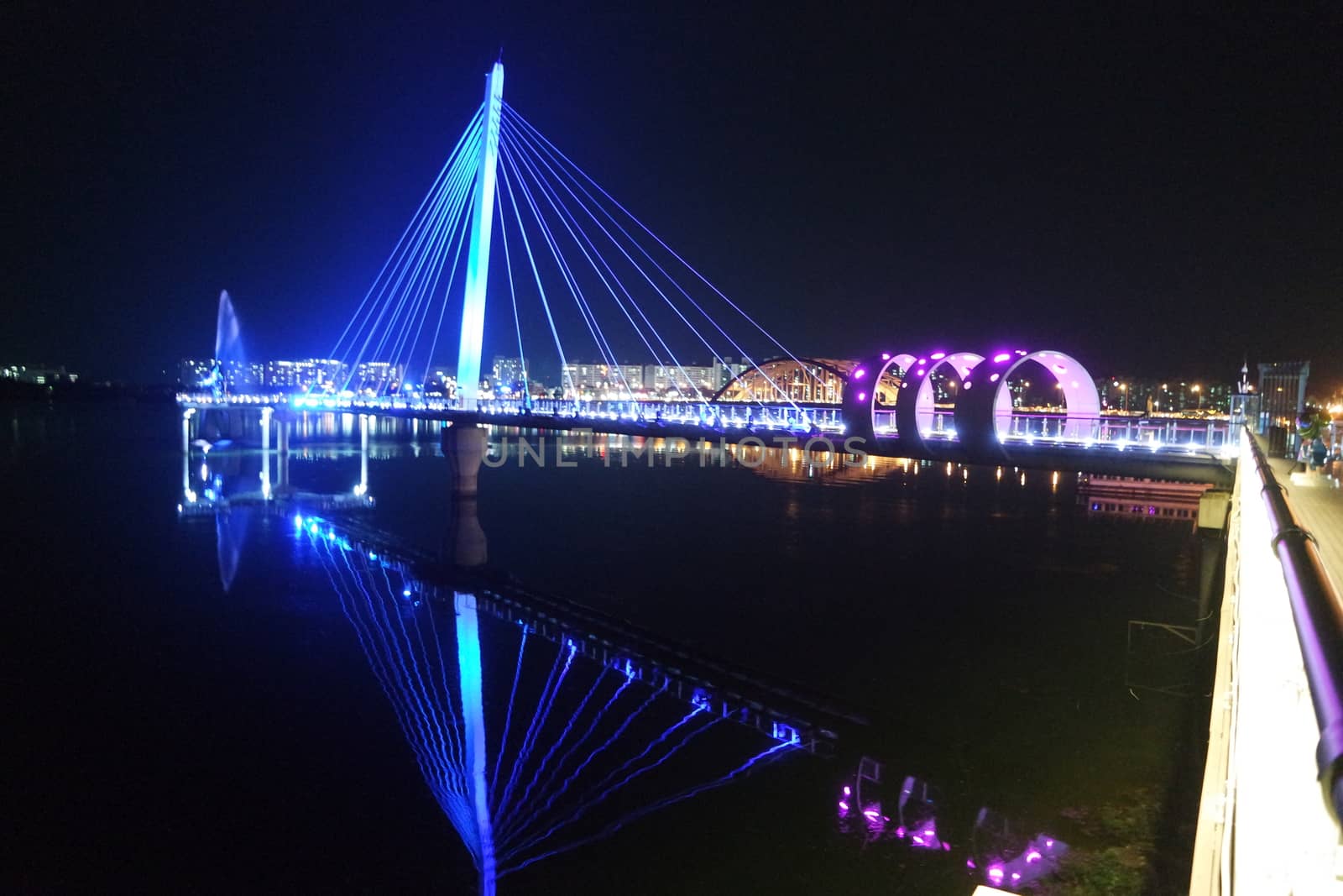 Night view of a beautiful scene of bridge over sea water in the evening time with colorful lights.
