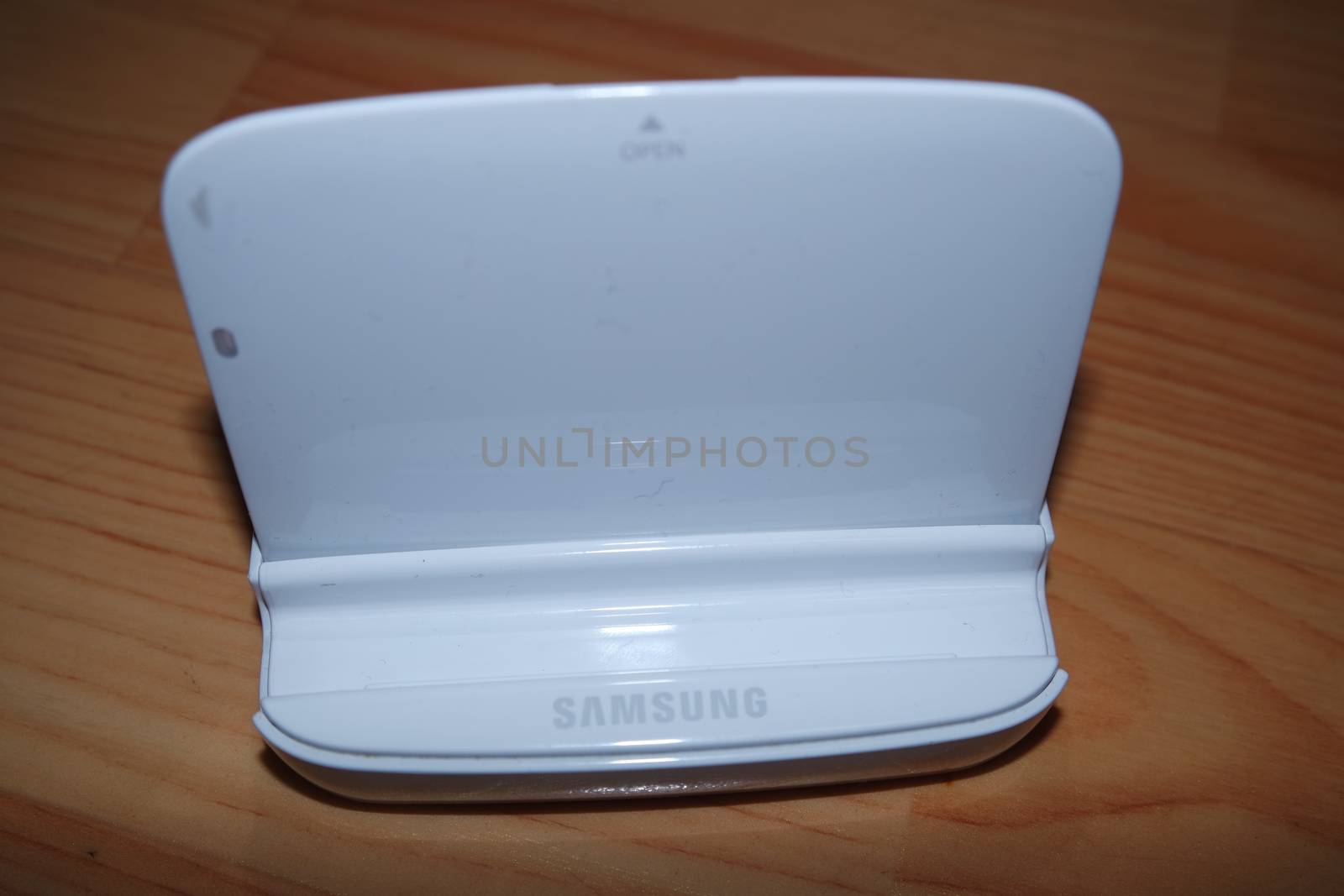 White colored battery charging box for electronic devices like mobile phone. Potable charging box is placed on a wooden floor.