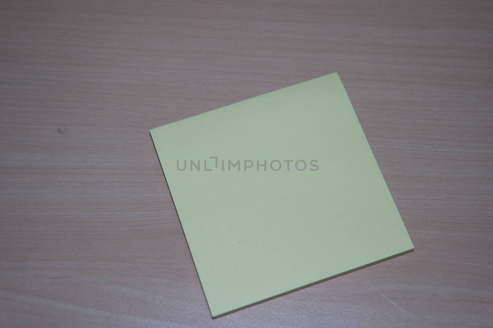 Close-up, selective focus: Yellow sticky note paper placed on a wooden table with copy space for text