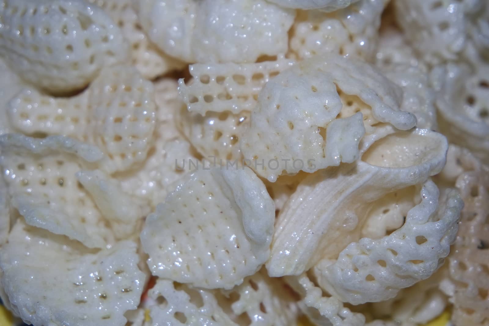Closeup view of freshly fried chips as fast food for tea break. Potato chips with spices sprinkled on it. Fast food background for advertisements.