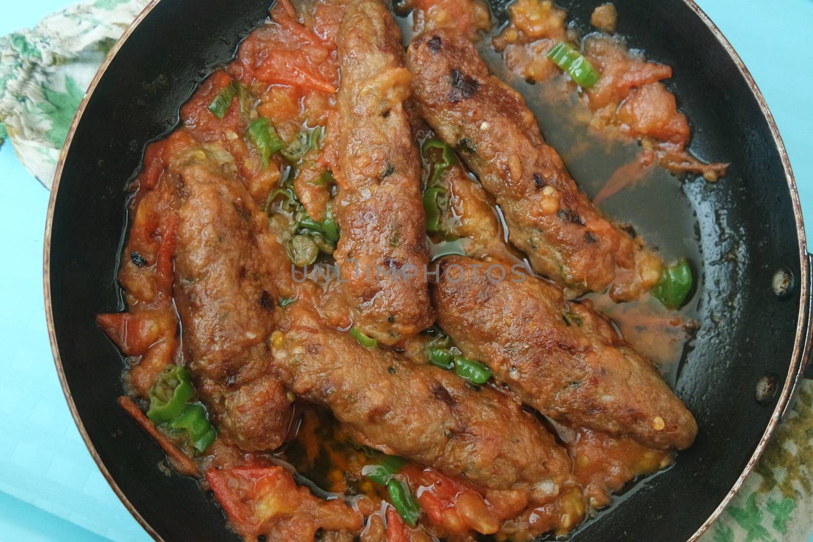 Closeup view of delicious spicy home made fried kebab with green mint leaves and green pepper sprinkled on it