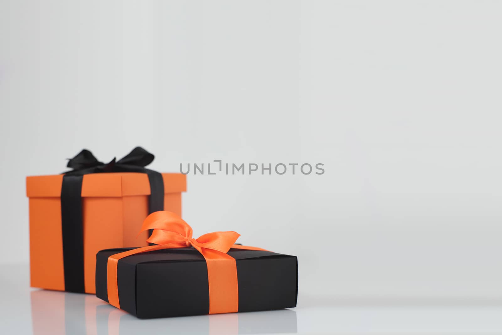 Decorated black and orange color halloween gift boxes on gray background with copy space for text, corner composition