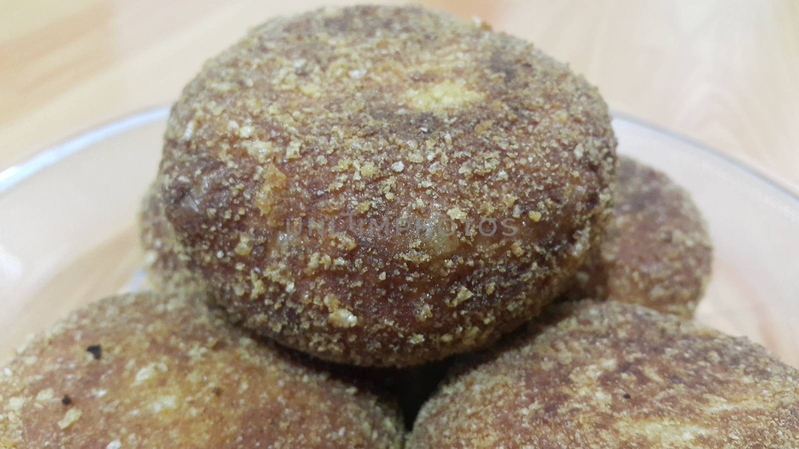 Closeup perspective view of fried pizza bomb or pizza balls served in a glass plate over wooden floor. Pizza bombs are delicious and tasty altered form of pizza.