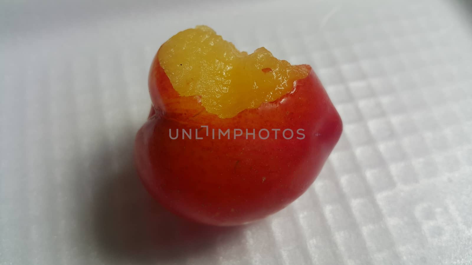 Closeup view of red plum on a white grey background. Freshly harvested plum making heart shape appearance in the view from angle.