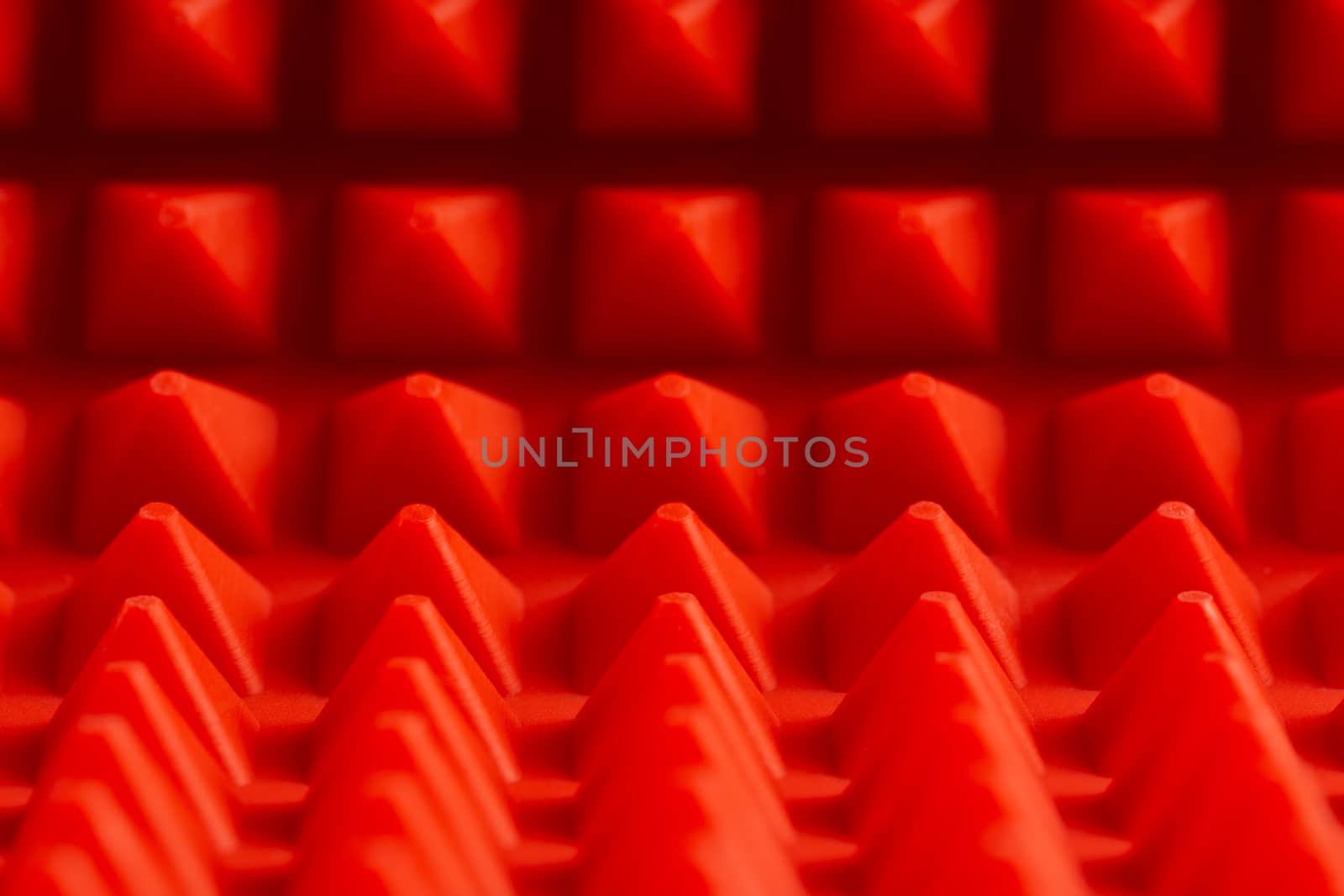 abstract red silicone pyramids mat close-up background.