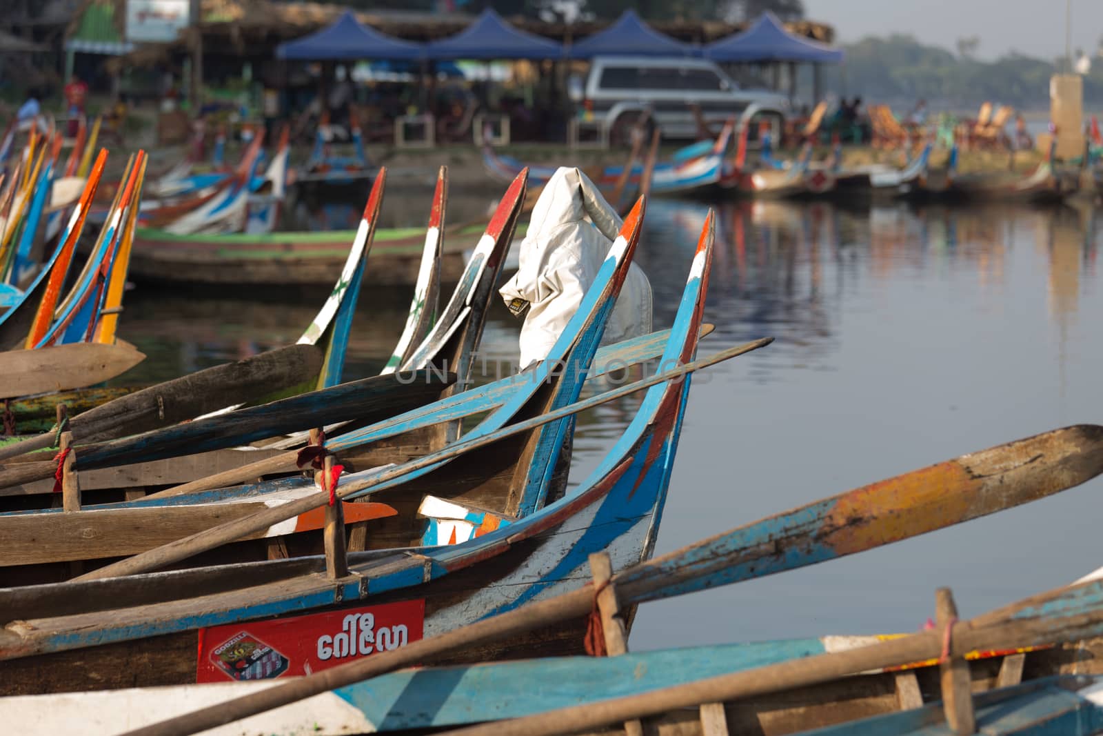 Colourful boats moored at Taungthaman Lake near Amarapura in Myanmar by the U Bein Bridge . High quality photo